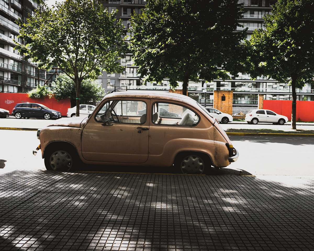 buenos aires brown 3-door hatchback parked near road gutter car